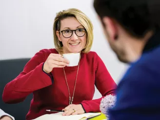 Lady holding a mug during an informal meeting
