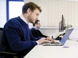 A man using a laptop at a desk
