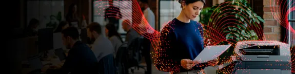 Woman standing in front of a Sharp MFP looking at a document