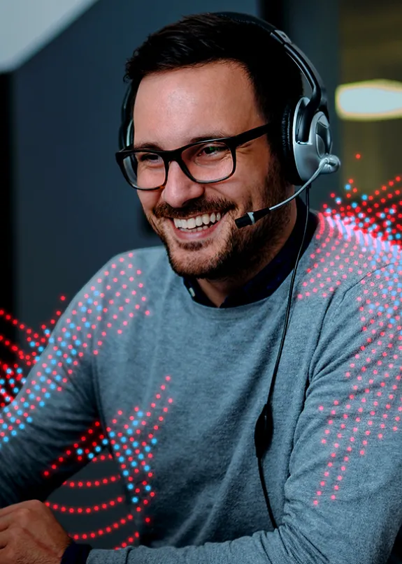 Man looking at a computer whilst talking on a headset
